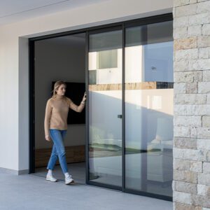 Mujer joven abriendo una ventana corredera